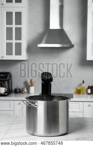 Pot With Sous Vide Cooker On Table In Kitchen. Thermal Immersion Circulator