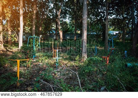 Old Outdoor Exercise Equipment So Worn Out And Covered In Trees In Outdoor Exercise Park. Old Abando