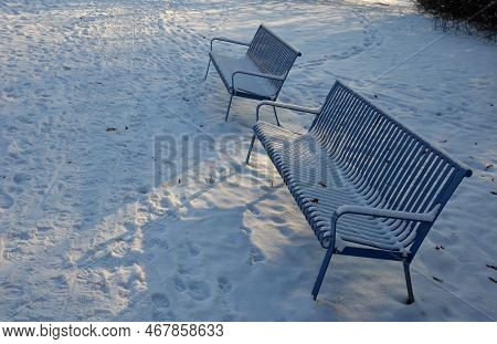 Park Benches In Light Blue Made Of Metal Strips Similar To A Lattice. Trash Can And Beautiful Lawn W