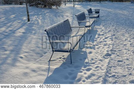 Park Benches In Light Blue Made Of Metal Strips Similar To A Lattice. Trash Can And Beautiful Lawn W