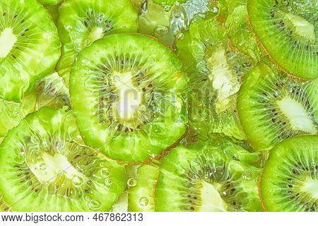 Slices Of Kiwi Fruit In Water On White Background. Kiwi Fruit Close-up In Liquid With Bubbles. Slice