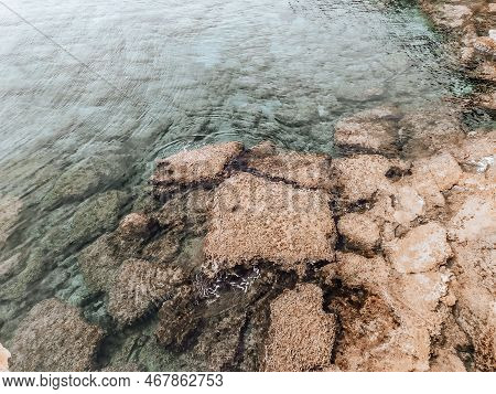 Rocky Seabed With Clear Blue Water. Lagre Stones In The Water. Autumn Soft Background. Mediterranean