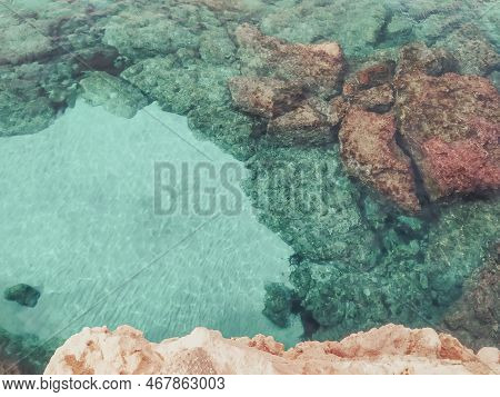 Lagre Stones In The Blue Water. Top View From The Cliff. Rocky Bottom Of The Sea With White Sand.