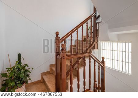Spacious Staircase With Marble Steps And Wooden Railings Leading To Upper Floor Against Backdrop Of 