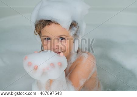 Children Bathing. Kid Having Fun In The Bath With Bubbles. Happy Child Enjoying Bath Time. Little Bo