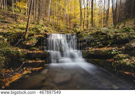 Vlasky River With Waterfall Illuminated With Sun In An Untouched Landscape In The Middle Of An Autum