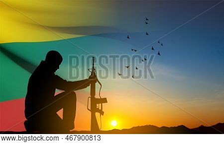 Silhouette Of Soldier Kneeling Down With The Flag Of Lithuania On Background Of Sunset. Armed Forces