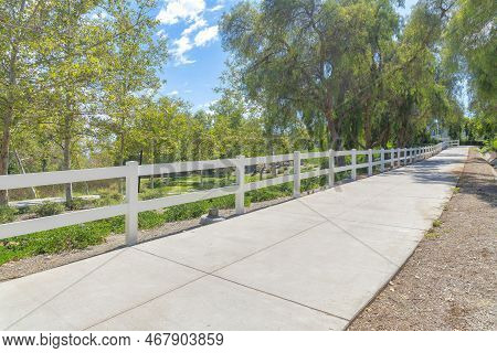 Small Concrete Path With White Fence Barrier And Trees At Ladera Ranch In South California. Empty Pa