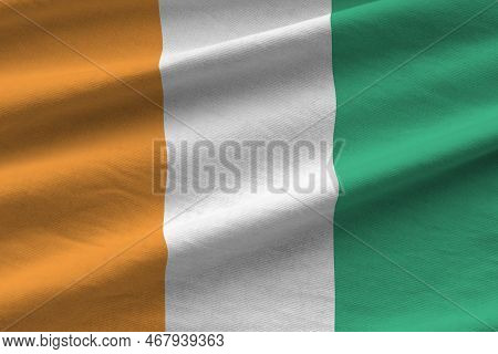 Ivory Coast Flag With Big Folds Waving Close Up Under The Studio Light Indoors. The Official Symbols