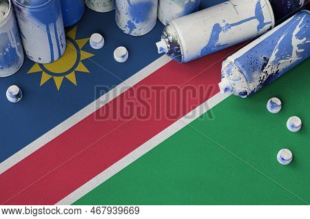 Namibia Flag And Few Used Aerosol Spray Cans For Graffiti Painting. Street Art Culture Concept, Vand