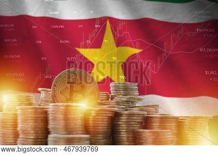 Suriname Flag And Big Amount Of Golden Bitcoin Coins And Trading Platform Chart. Crypto Currency Con