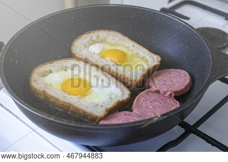 Egg With Sausage In Bread, In A Frying Pan. Cooking Breakfast On A Gas Stove