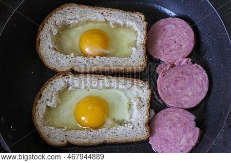 Egg With Sausage In Bread, In A Frying Pan. Cooking Breakfast On A Gas Stove