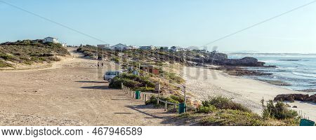 Arniston, South Africa - Sep 22, 2022: Buildings, A Vehicle And People Are Visible At The Parking Ar