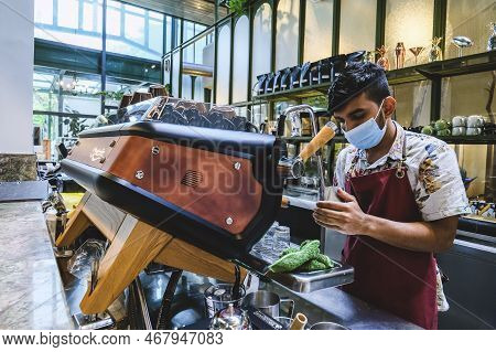 Kuala Lumpur, Malaysia - Februry 23, 2022: Professional Barista Poured Hot Milk Into A Hot Espresso 