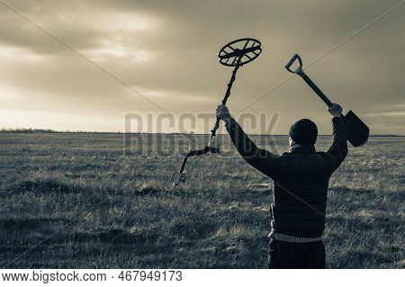 A Happy Treasure Hunter With A Metal Detector On The Background Of A Beautiful Sunset