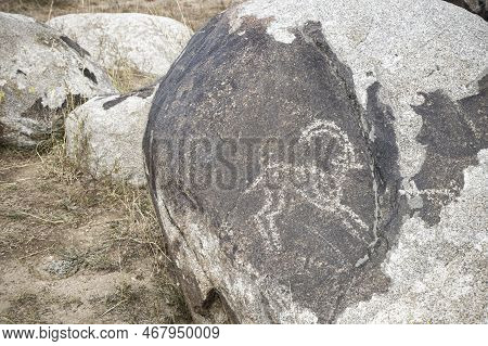 Petroglyphs On The Rocks In Kazakhstan. The Ancient Parking Cave Man. Historical Cave Paintings. Car