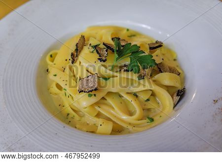 Fresh Pasta With Truffle Sauce, Topped With Shaved Black Truffles And Shaved Parmesan Cheese At An I