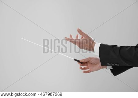 Professional Conductor With Baton On Light Grey Background, Closeup. Space For Text