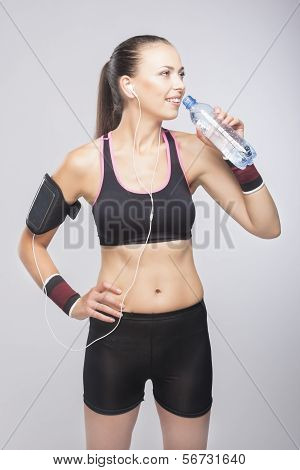 Fit Woman Training While Dringking Form Small Bottle - Isolated Over Gray Background