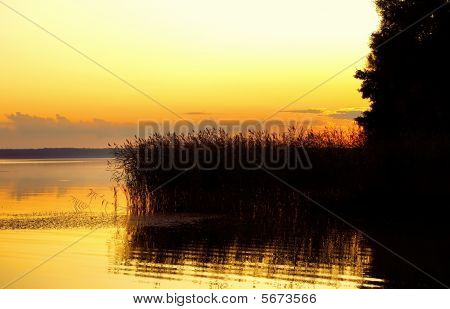 Paysage avec coucher de soleil sur le lac