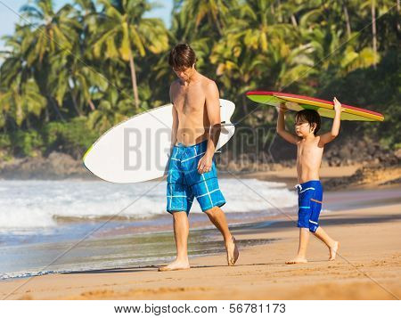 Father and Son Going Surfing Together on Tropical Beach in Hawaii