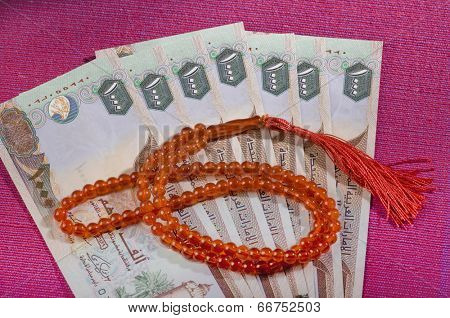 UAE dirham currency notes and a rosary - sharia finance objects
