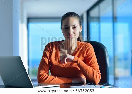beautiful young woman relax and work on laptop computer while listening music on heaphones and read book at home