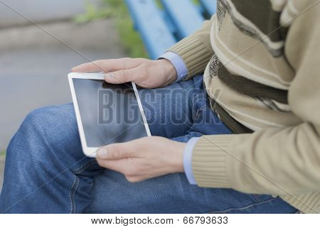 Man With Tablet In Park.