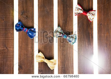 Set of handmade bow tie over wooden background