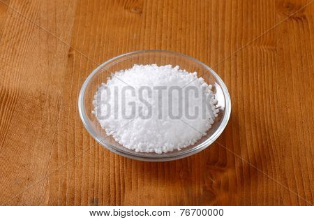 glass bowl with raw salt on the wooden table