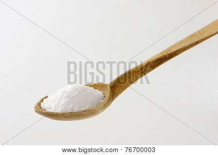 whit of coarse grained salt on the old wooden spoon