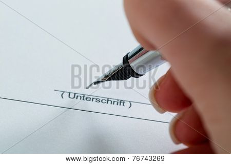 a hand with a fountain pen in the untrerschrift under a contract or testament.