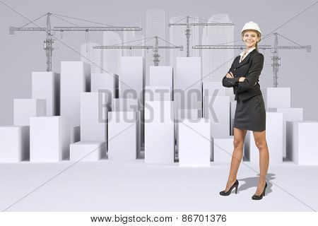 Business woman and white cubes with wire-frame buildings, tower cranes