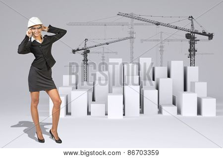 Business woman in glasses. Full lenght. Cubes with tower cranes