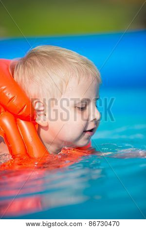 Pretty little boy in swimming pool