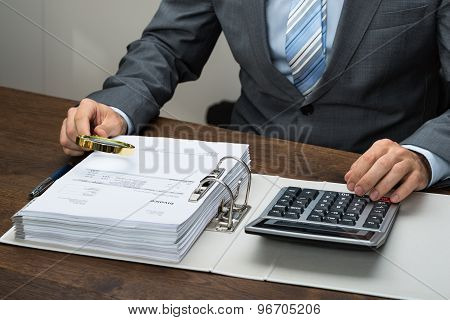 Businessman Inspecting Receipts In Office
