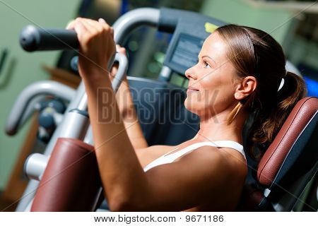Kvinna i gymmet på maskin utövar