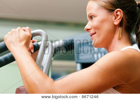 Kvinna i gymmet på maskin utövar