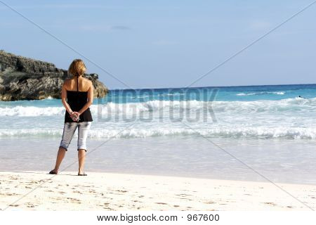 Playa y mujer sosteniendo el teléfono celular