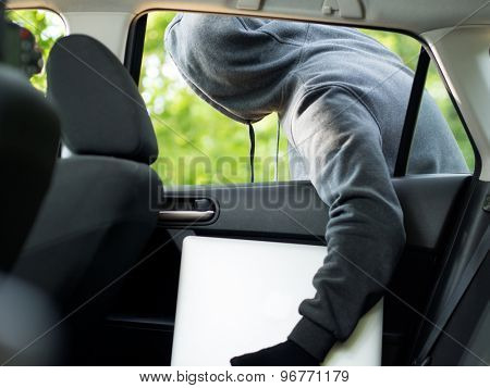 Car theft - a laptop being stolen through the window of an unoccupied car.  