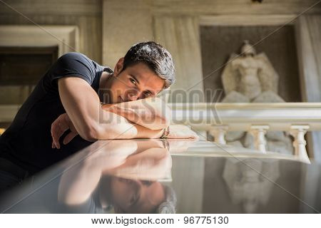 Young Man Resting with Head on Staircase Railing