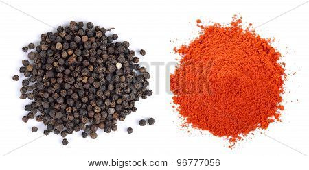 Pile Of Red Paprika Powder And Black Pepper Seeds On White Background