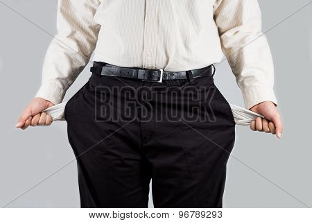 Man in office wear pulling out empty pockets from his pants