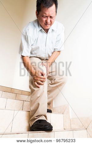 Matured man suffering with acute knee joint pain when descending steps