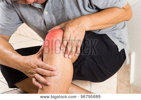 Matured man suffering from painful knee joint seated on steps