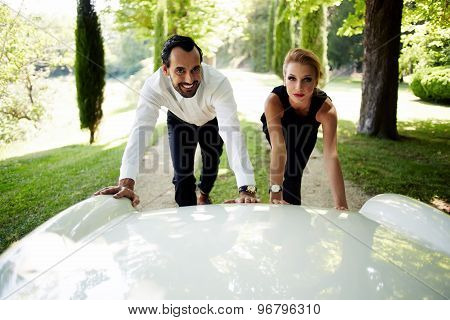 Attractive young couple of travelers faced with the problem their luxurious new white car broken