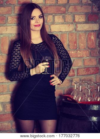 Woman Tasting Wine In Rural Cottage Interior