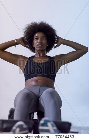 young fit african american woman doing sit ups in fitness studio at the gym.Abdominal exercises Sit up