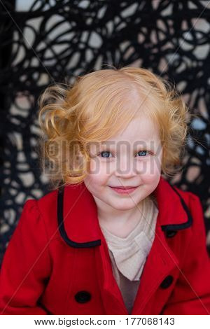 Portrait Of A Beautiful Little Girl With Red Hair In A Red Coat